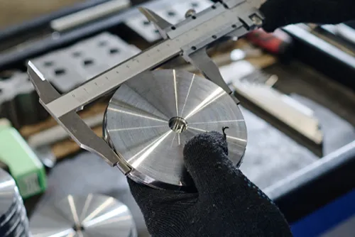 Veit Tool Metalworker using a caliper to test the precision of a custom metal part Veit Tool Metalworker using a caliper to test the precision of a custom metal part